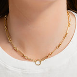 Gold chain necklace worn by a person on a white background
