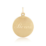Gold pendant with 'Beau' engraved on a white background