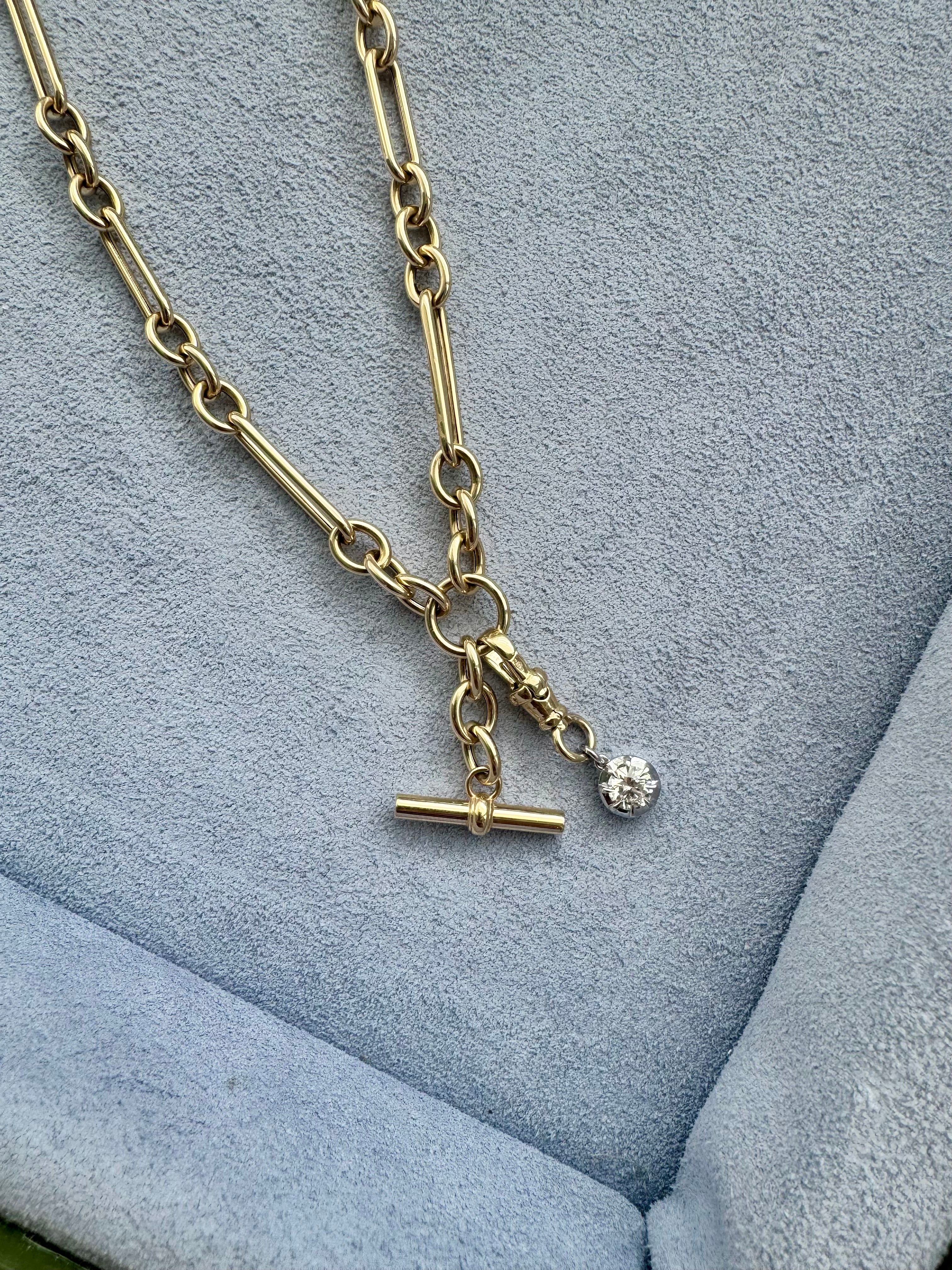 Gold necklace with a pendant on a textured blue surface