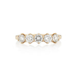 A Victorian style diamond ring with five stones set in a gold band with a buttercup setting.