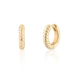 A pair of small gold huggie hoop earrings with a twisted rope texture, shown from the front and side on a reflective white surface.