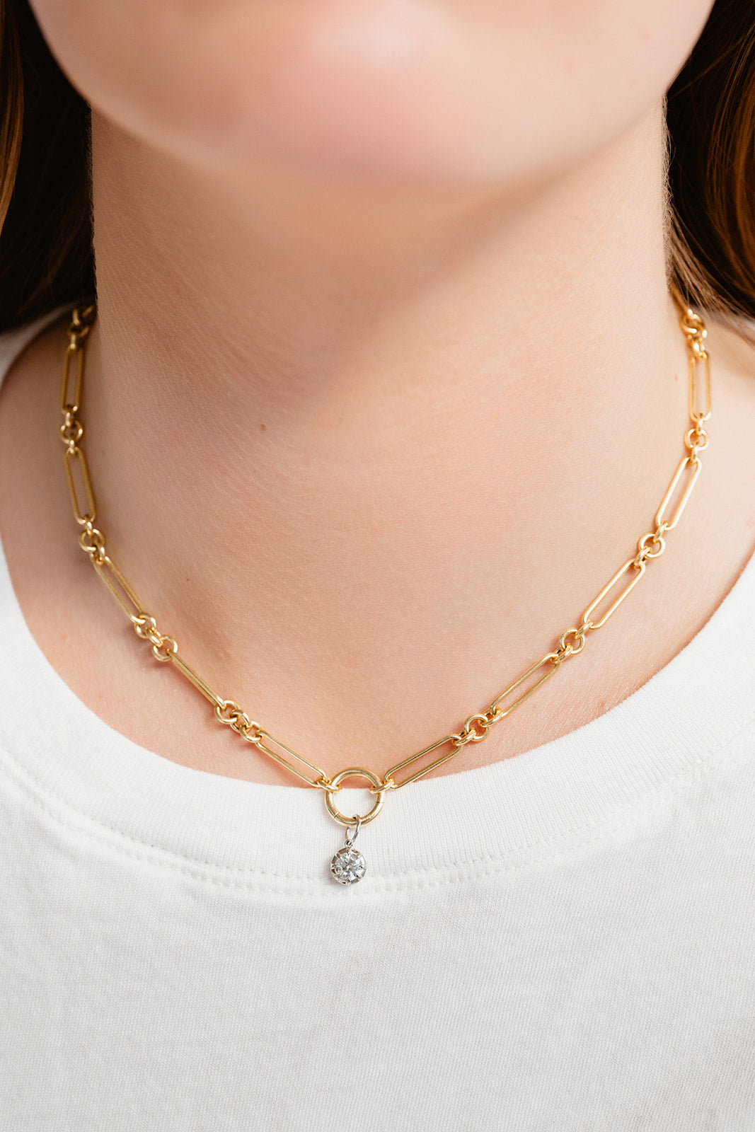 Gold chain necklace with a small pendant on a white background