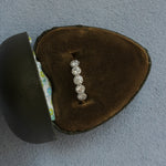 Diamond ring in a brown velvet box on a gray background