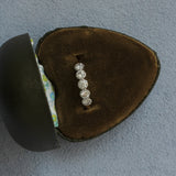 Diamond ring in a brown velvet box on a gray background