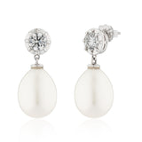 Pair of earrings with white teardrop stones and clear gemstones on a white background