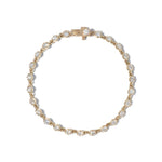 A close-up image of a gold tennis bracelet with mini collet settings featuring round brilliant diamonds.