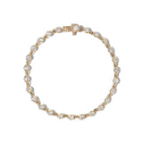 A close-up image of a gold tennis bracelet with mini collet settings featuring round brilliant diamonds.