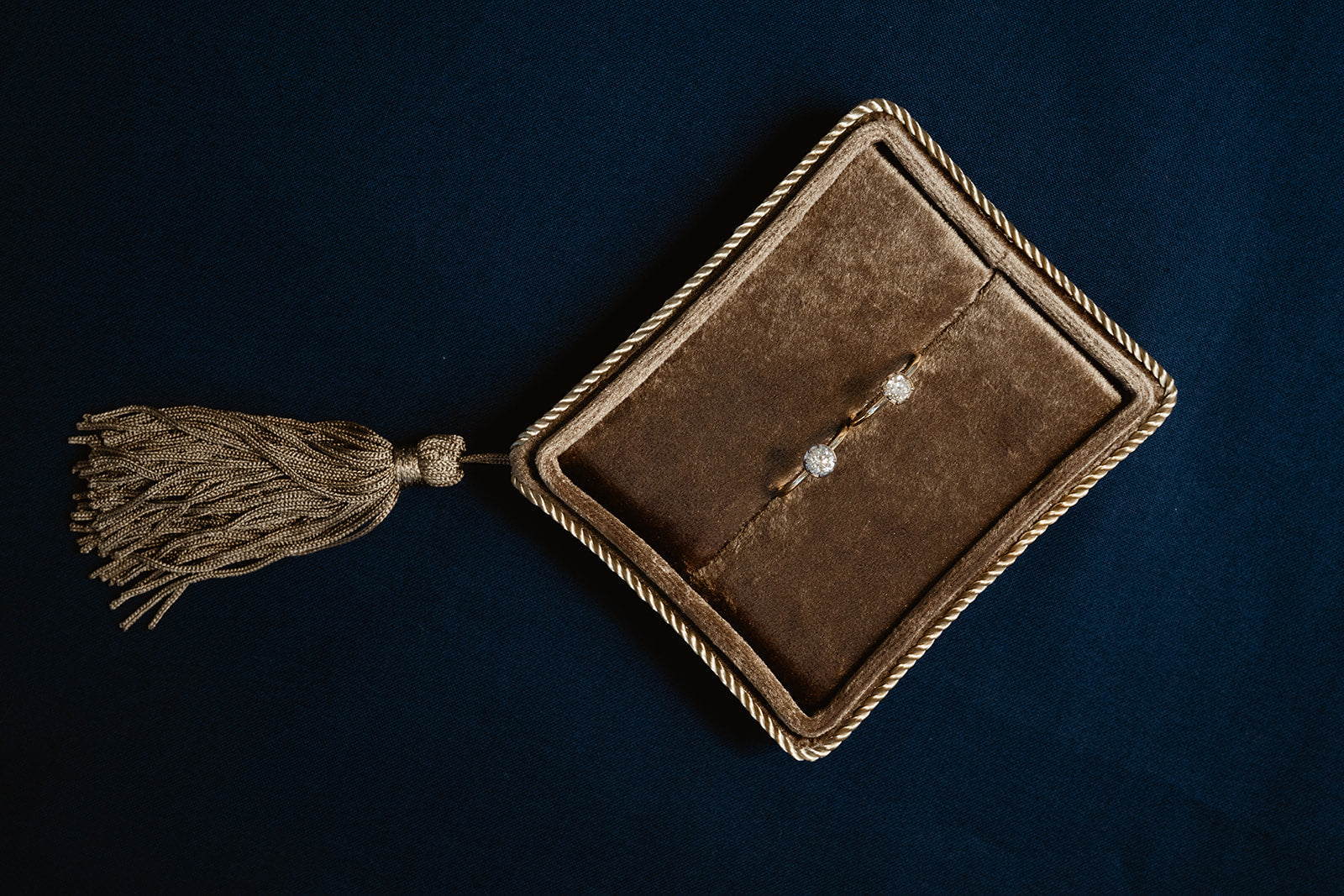 Brown velvet jewelry box with tassel on a dark background